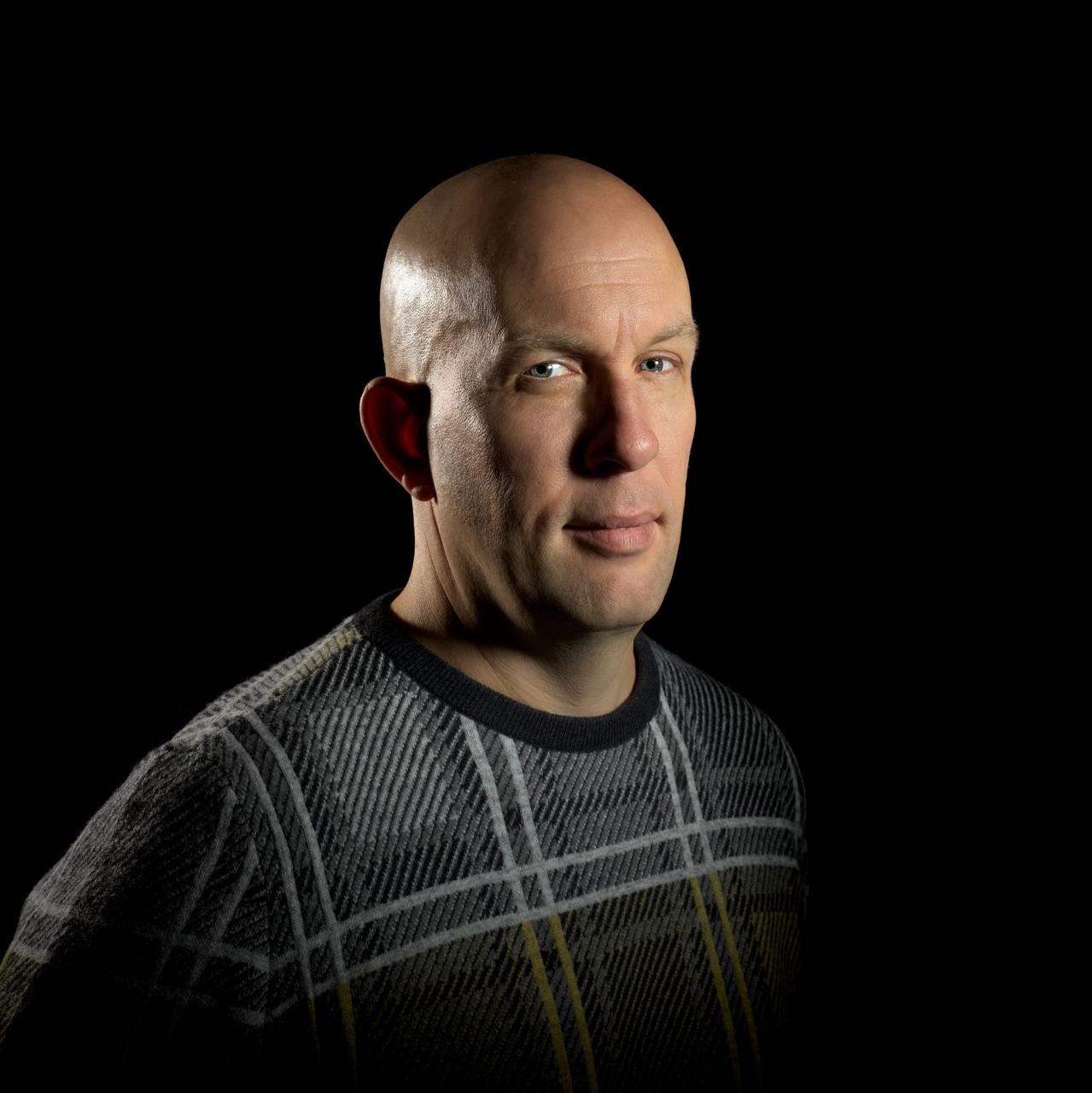 Edward Haak, schuin naar de camera gekeerd tegen een donkere achtergrond